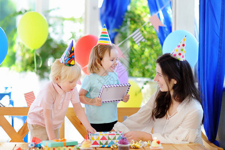 小孩和他们的妈用五颜六色的装饰和蛋糕庆祝生日聚会图片