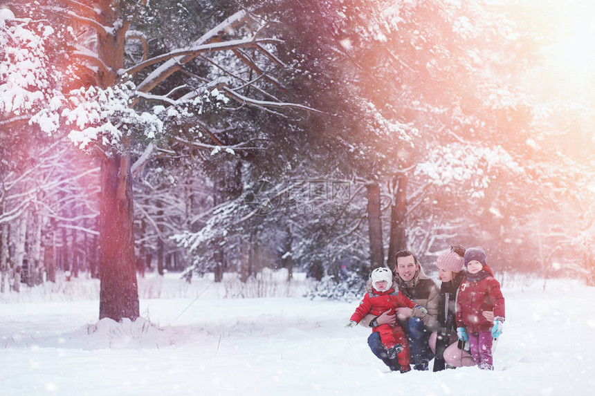 带着孩子的年轻家庭正在冬季公园散步父母带着孩子的冬天散步在冬天的图片
