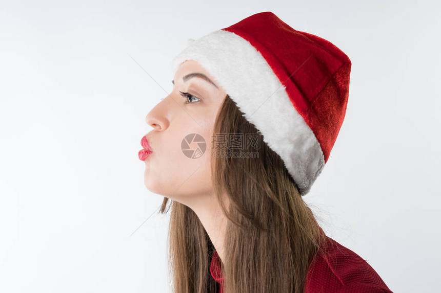 穿着红色圣达克萨斯帽的年轻圣诞节妇女肖像被复制空间击穿图片