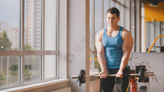 在健身房里锻体肌肉男在附近训练图片