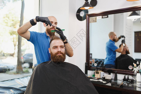 男专业美发师用剪刀为客户服务图片