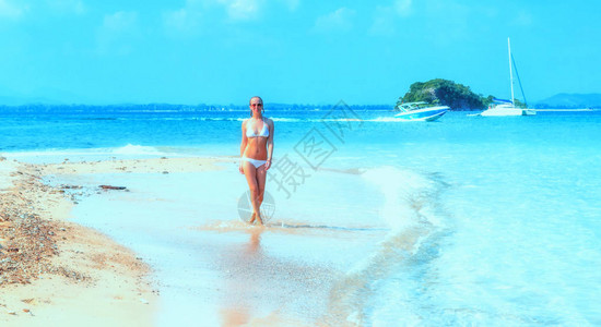 走在泰国沙美岛海滩上的年轻女子图片