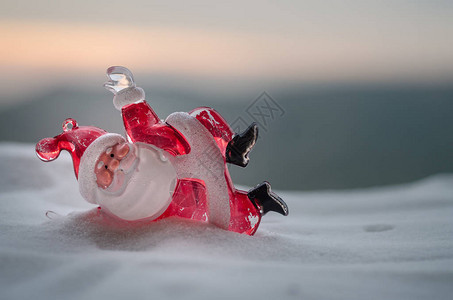 圣诞快乐圣诞老人娃与树和雪模糊的户外背景圣诞老人和圣诞快乐模型人物玩具背后的散焦自然背景背景图片