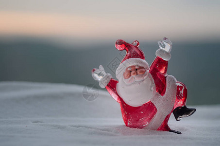 圣诞快乐圣诞老人娃与树和雪模糊的户外背景圣诞老人和圣诞快乐模型人物玩具背后的散焦自然背景背景图片