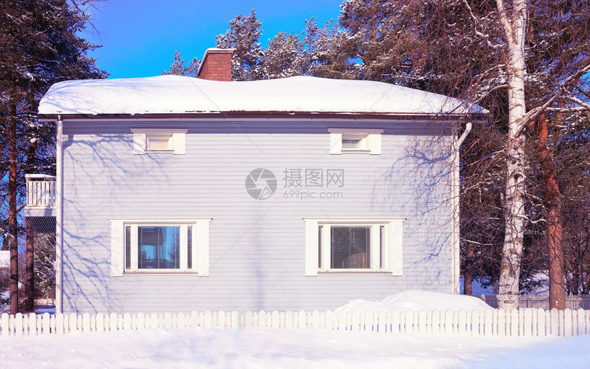 芬兰罗瓦涅米冬季的舒适小屋和树木图片