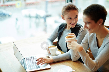 有魅力的年轻女子喝着美味可口的卡布奇诺聚在咖啡厅时聊天动图片
