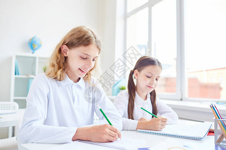 创意学生用铅笔在字帖上画背景图片