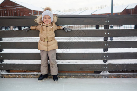 冬天穿冬装快乐的孩子站在滑冰场图片