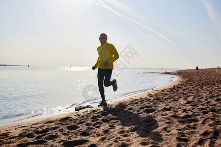 运动老人在海滨上奔跑图片