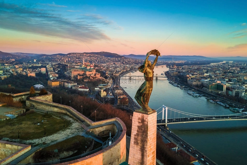 布达佩斯匈牙利自由女神像与布达城堡皇宫和链桥背景的空中地平线观清晨的日出与图片