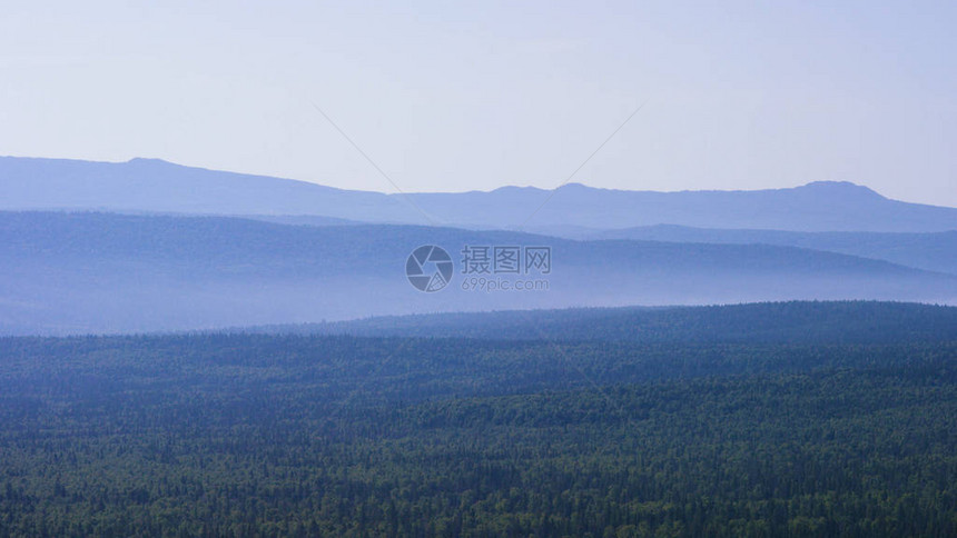 绿色山脉的壮丽全景与阳光明媚的光束晨雾中的群山夏季景观来自针叶林的雾在夕阳的照耀图片