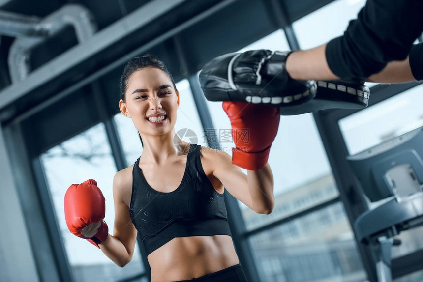 有表现力的年轻女拳击手在健身房锻炼训练图片