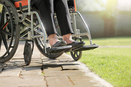 血压高老年妇女在后院的轮椅上肿脚背景