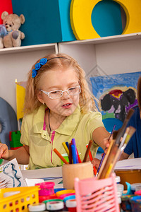 小学生在艺术学校课上画孩子在桌子上用颜料画幼儿园里的男孩和女孩水彩画笔刷的最佳选择背景图片