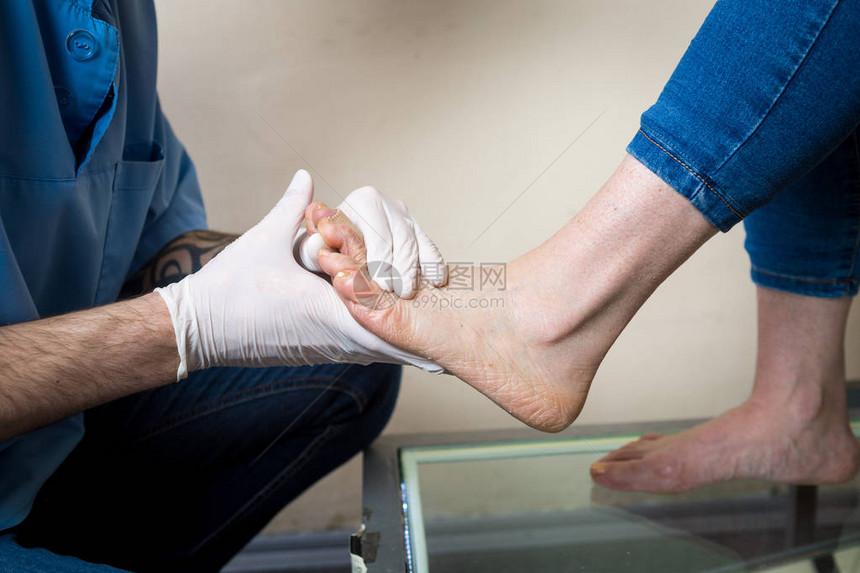 一个年轻人的手医生骨科进行诊断足尺测试的一个女人为制造个人矫形鞋垫图片
