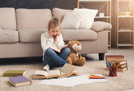 小女孩与书和她最喜爱的玩具在家图片