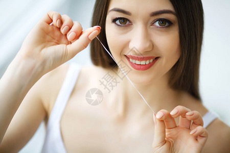 牙齿护理美丽的微笑的女人牙线健康的白牙齿图片