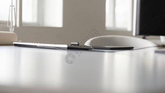 一个平板电脑和钢笔在白色办公桌的图片