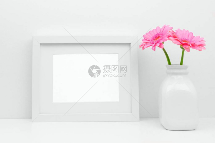 在架子或桌子上的花瓶中模拟白色框架和粉红色的雏菊花图片