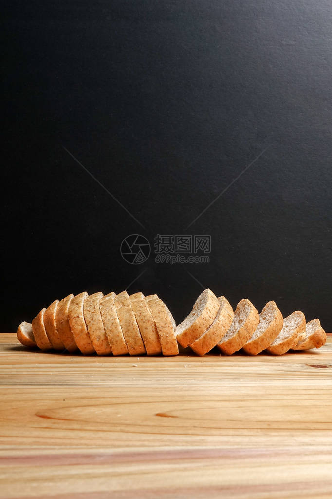 一条木质背景上的全麦面包图片