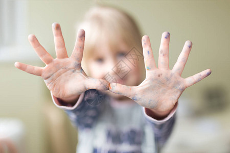 快乐的小孩用涂料把手弄脏享受艺术图片