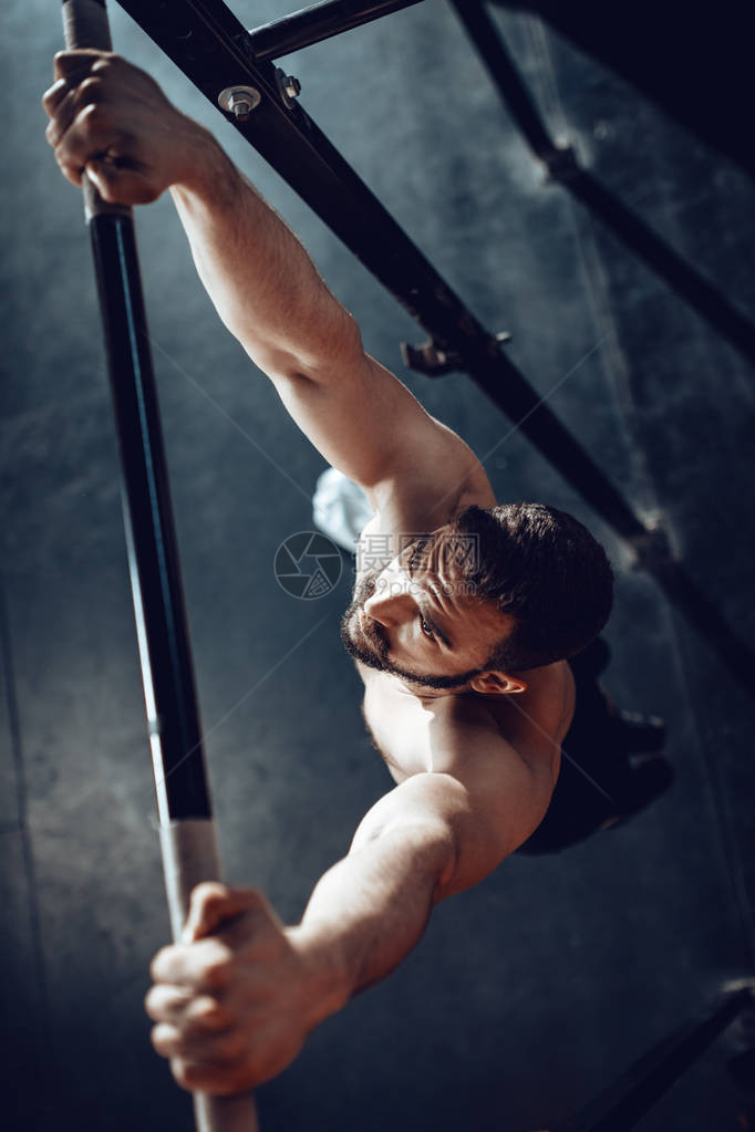 强壮的年轻肌肉男在健身房做拉图片