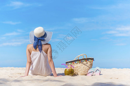 夏天在海滩上旅游背景的概念美丽的女人后侧坐在沙滩上仰望蓝天快乐的假期和漫长的周末图片添加信息设计艺术作品背景图片