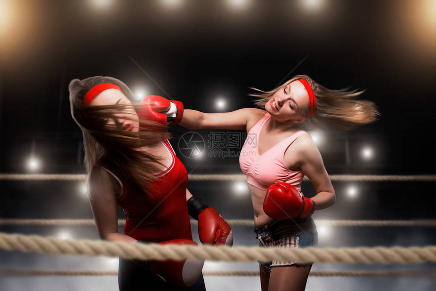 两个女kickboxers在拳击场上打架图片