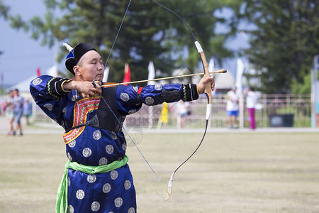 比赛在西伯利亚的体育弓蒙古射箭比赛这位运动员穿着传统的布里亚特蒙古西服在时用箭背景图片