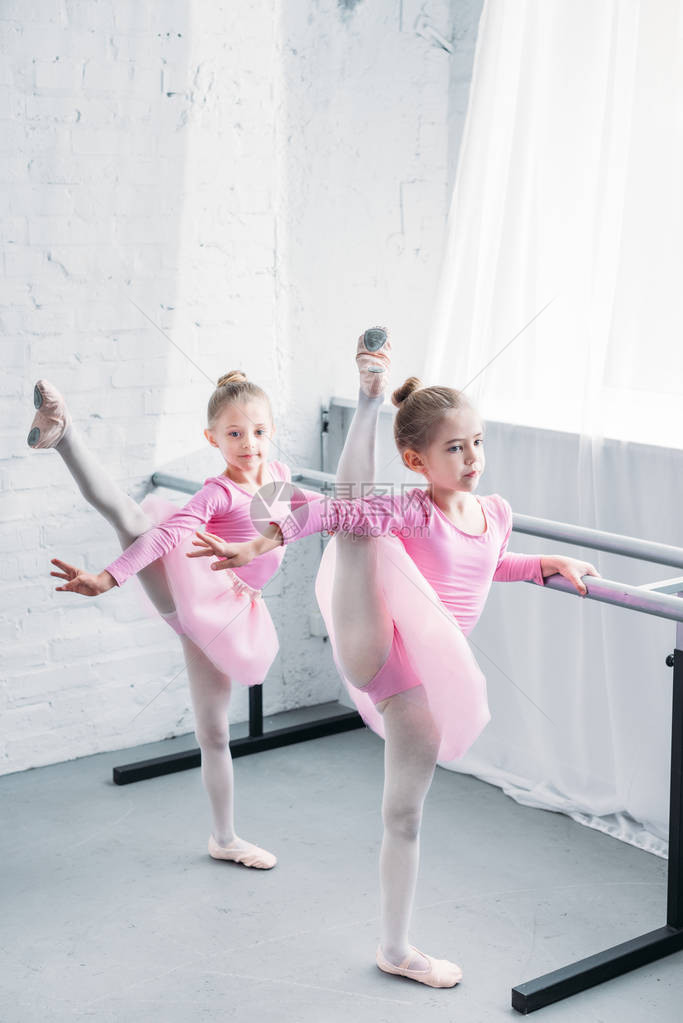 可爱的小孩子在粉红色的短裙裙伸展和舞蹈芭蕾学校图片