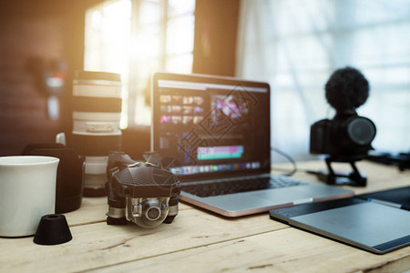 外置硬盘Youtuber创意和Vlogger编辑在办公室的配件齿轮笔记本电脑镜头摄像头和无人机并编辑视频上传到背景