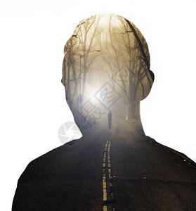 在剧烈的日出场面中在薄雾缭绕的森林道路上男头部与人的双重接触图片
