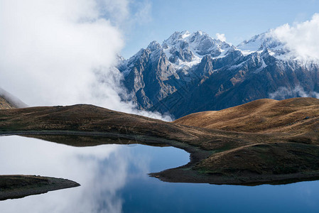 海岭下一个高山湖泊的风景天与美丽的云彩Koruldi湖主要的高加索脊上斯瓦涅季格鲁吉亚背景