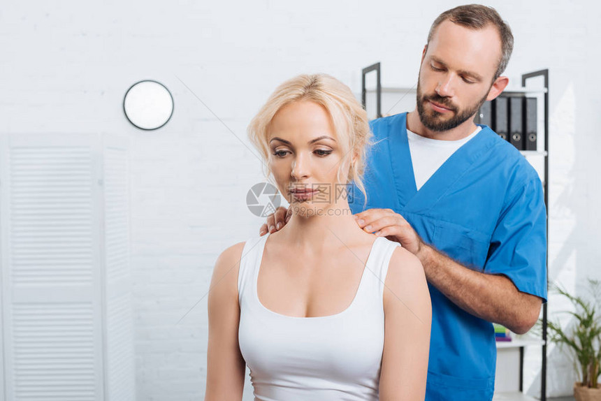 医用推拿师在医院里按摩女人肩的肖像图片