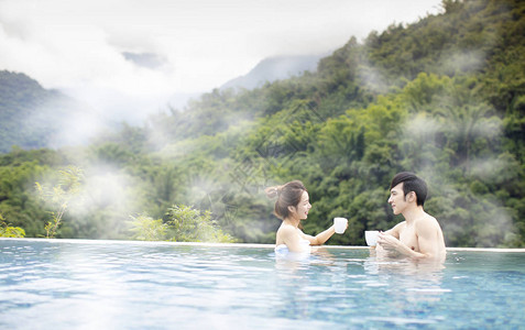 年轻的亚洲情侣在温泉放松图片