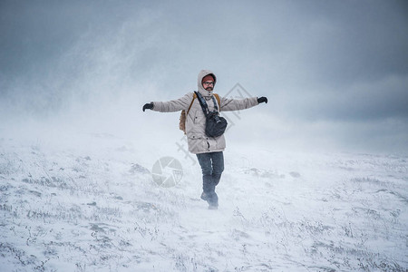 在暴风雪或冰暴中颤抖的人冬日场景走在山图片