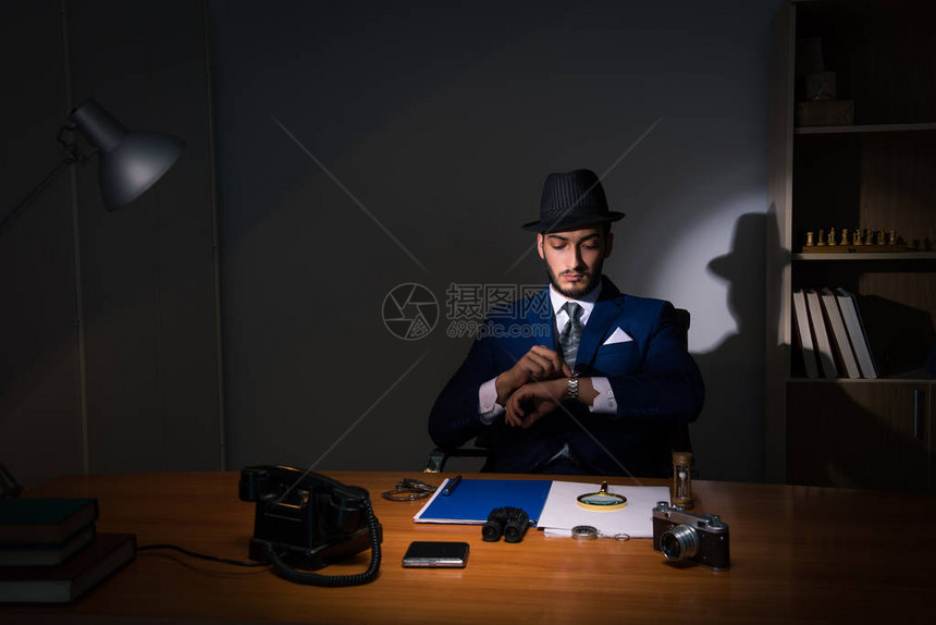 侦探坐在黑暗的房间里的老式概念图片