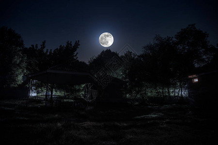 解梦夜晚用月亮或老式乡村住宅在森林中建造的山夜景观夜晚用云彩和星星夏夜长时间曝光拍摄的照片背景