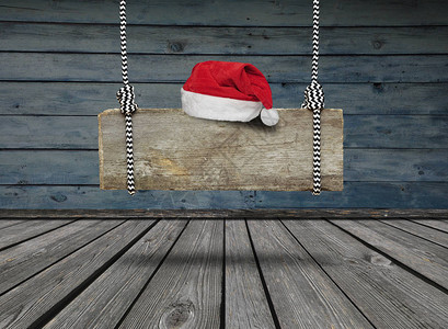 挂着圣诞老人帽子的旧木条横幅挂在一个黑鬼屋图片
