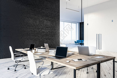 现代办公室的内部设有黑色蜂窝图案墙壁木地板四张带笔记本电脑的木桌和大堂的蓝色沙发3背景图片