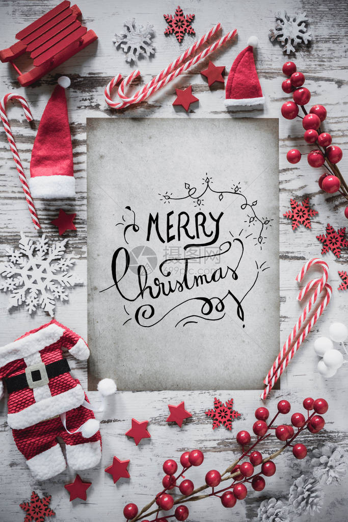 与书法圣诞快乐的垂直纸与雪的白色木背景平躺着圣诞装饰图片