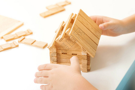 孩子建木房子关门孩子玩木积木小房子的缩影家庭住宅概念家庭家庭未来的概念孩子梦见自己的房子背景图片