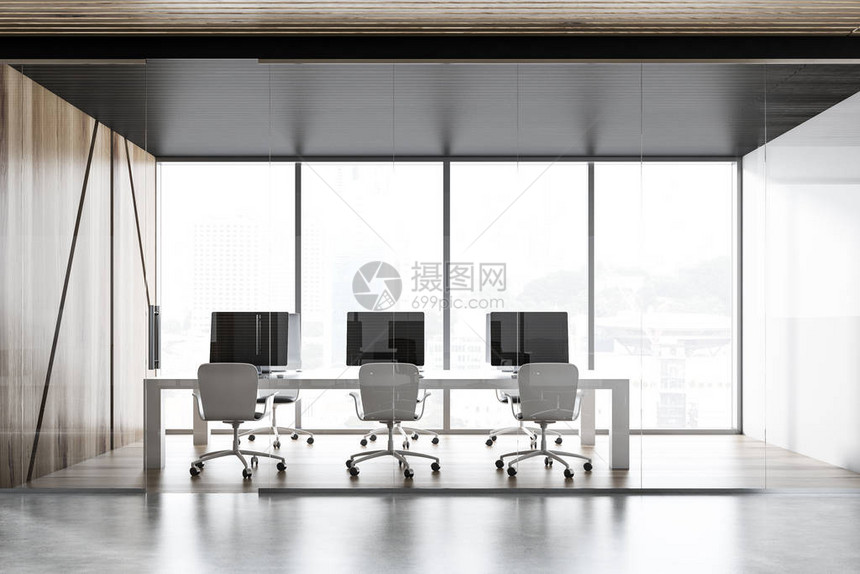 内置有全景窗木墙和白墙木地板和带显示器的长白色计算机桌的开放空间办公室图片