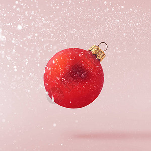 圣诞节的概念创意圣诞构想是在粉红色背景下坠入空气中闪亮的小玩意图片