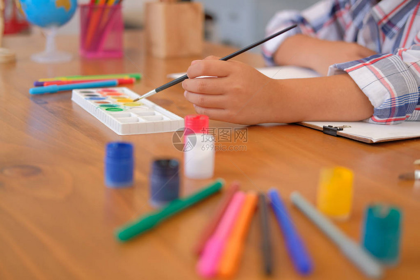 亚洲小孩男儿童男小学生拿着画笔绘画水彩儿童图片