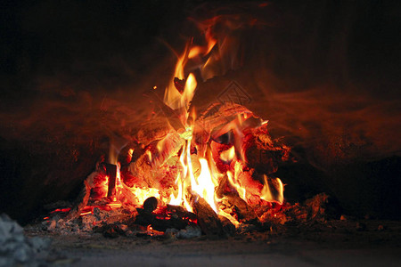 在炉子里燃烧木材木柴在农村烤箱里燃烧在壁炉特写中燃烧木柴火和火焰靠近壁炉里燃烧的木柴背景图片