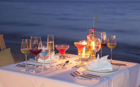 Oberstdorf轮廓玻璃的葡萄酒和设备在木制桌子上海景和天际线在晚上与日落色调风格背景