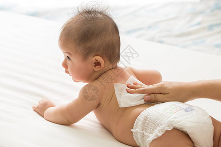 母亲用湿纸巾清洁身体和腿部婴儿图片