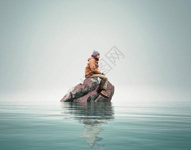 人站在海中央的一块岩石上图片