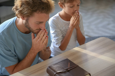 父亲和儿子在家祈祷图片
